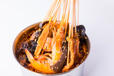 很多串串食材泡在一个装有红油麻辣火锅浓汤