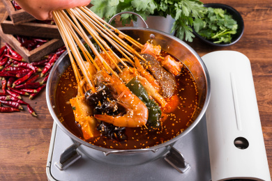 手握一把刚从火锅麻辣浓汤拿起的串串