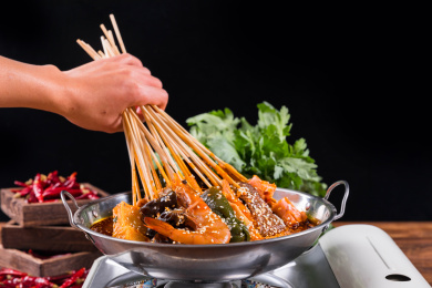 手握一把刚从火锅麻辣浓汤拿起的串串