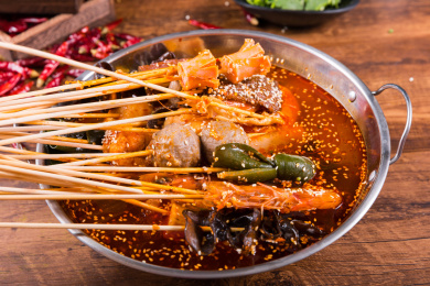 一个盆里面装有麻辣红油和火锅串串