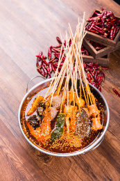 一个盆里面装有麻辣红油和火锅串串