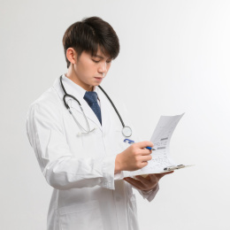  白色背景里的正在文件夹上写字的亚洲年轻男医生