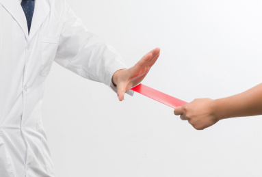 白色背景里拒绝红包的亚洲年轻男医生