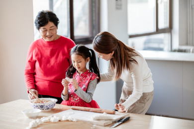 奶奶和妈妈在教小女孩包饺子