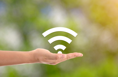 绿背景前一只手托起wifi符号