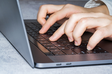 商务人士正在使用笔记本电脑打字录入信息写作编辑文字文章