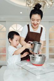 妈妈带着儿子正在厨房里做蛋糕