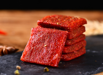 木纹背景上黑色餐具里摆放的拉片