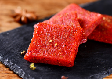 木纹背景上黑色餐具里摆放的拉片