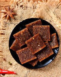 木纹背景上黑色餐具里摆放的辣片