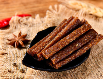 木背景上餐盘里摆放的香辣辣条