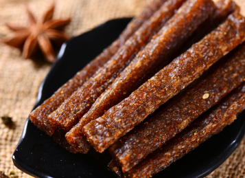 木背景上餐盘里摆放的香辣辣条