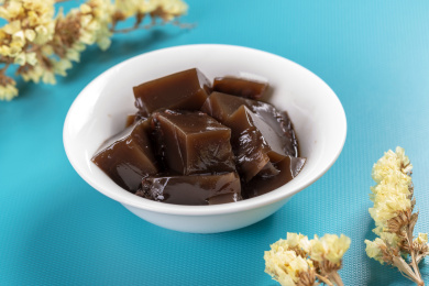 保健食品龟苓膏摆放在桌面上旁边有玉龟雕件