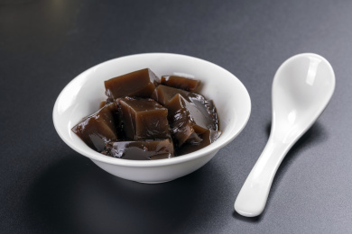 保健食品龟苓膏摆放在桌面上旁边有玉龟雕件