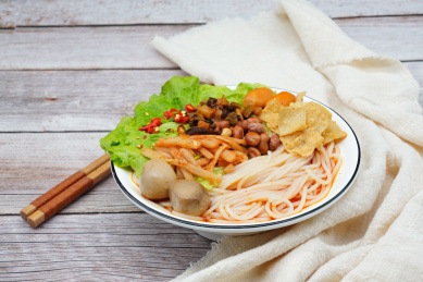 放在木板上的一碗螺蛳粉和配料