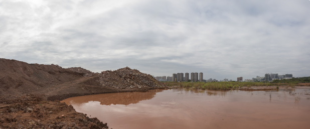 城市开发建设工地泥沙堆与水塘远景