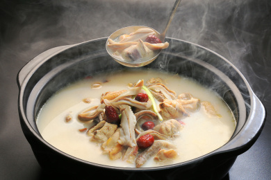 黑色背景上黑色汤锅里的冒着热气的猪肚鸡