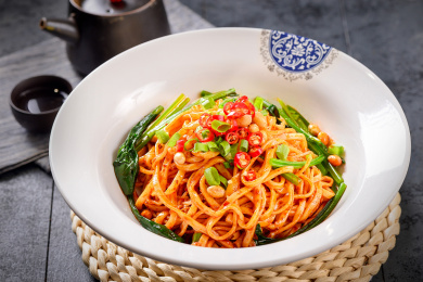 一盘红色红油拌面放在藤条上