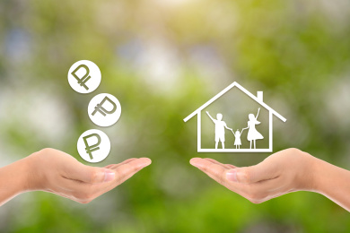 一只手托着虚拟的卢布硬币和另一只手托着装着一家三口的房子进行交易