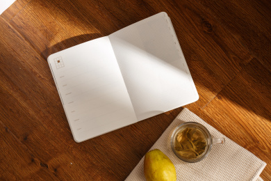 俯拍夕阳下阳台地板上放着的日记本和水果