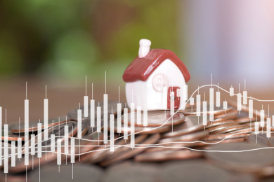 一堆美元硬币上一枚袖珍小房子