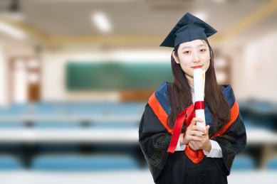 教室内毕业生穿着毕业服拿着毕业证书教育概念