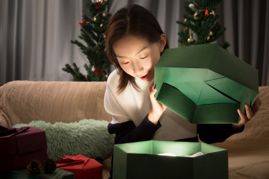 圣诞节收到礼物的美丽女孩打开礼盒惊喜又开心