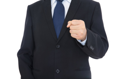 穿着正装的的男士伸手做握拳出击的手势