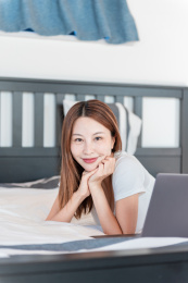 女子在床上躺着休闲办公