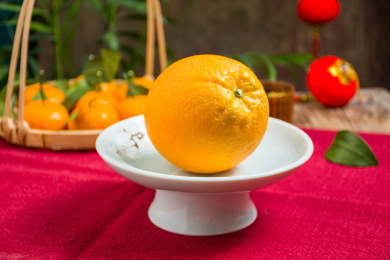 陶瓷果盘上放着一个完整的赣南脐橙