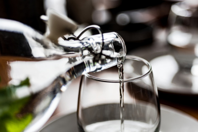 餐厅酒文化，正在往玻璃酒杯里倒酒