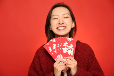 手里拿了一堆红包的中国女孩开怀大笑