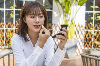 坐在室外咖啡桌前视频聊天的商务女青年