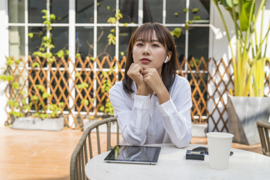 坐在室外咖啡桌前视频聊天的商务女青年