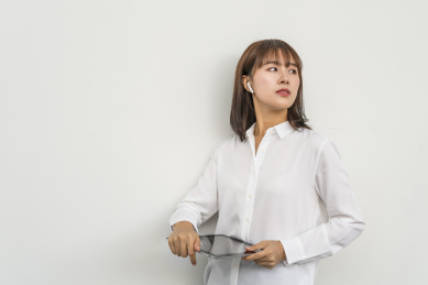 白背景墙前使用平板电脑的商务女青年