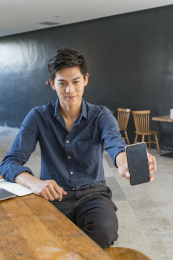 展示智能手机的商务男青年