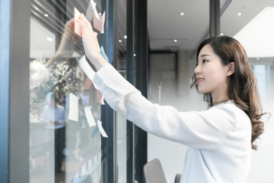 一名女性商务人士在会议中记录便利贴