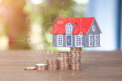 递增的美元硬币顶起一个小房子模型