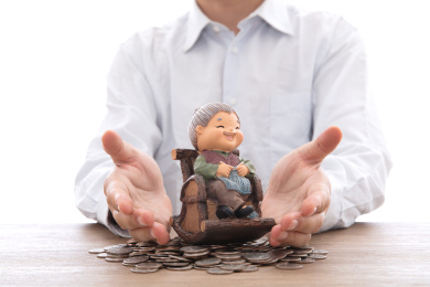 穿着白色衬衣的男士双手呵护着一个老奶奶模型