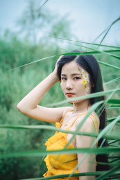 草坪上穿黄裙子的美丽女孩特写
