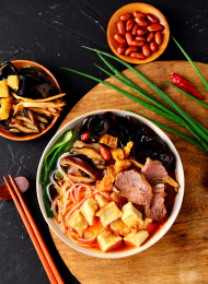 黑色背景上餐具里盛放的牛肉泡馍