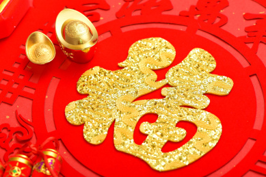 摆放着元宝和鞭炮的福字贴纸特写