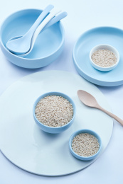 白色背景上的青釉瓷餐具装的燕麦米（莜麦）