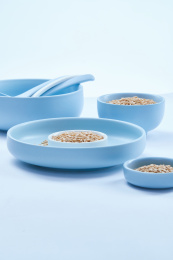 白色背景上的青釉瓷餐具装的燕麦米（莜麦）