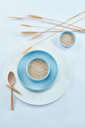 白色背景上的瓷质餐具装的燕麦米（莜麦）