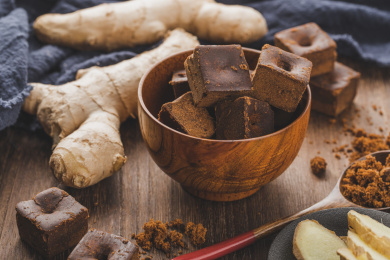 木制背景中碗中的红糖与生姜