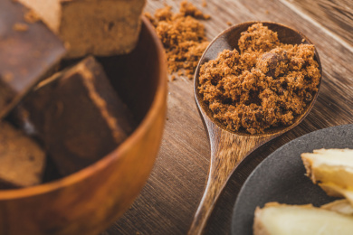 木制背景中碗中的红糖与生姜