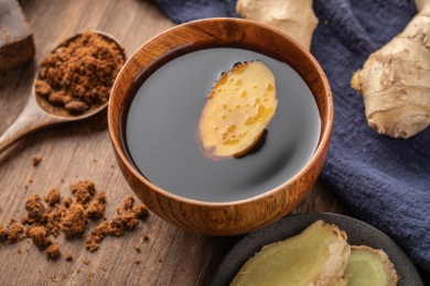 木制背景中碗中的红糖与生姜