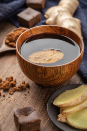 木制背景中碗中的红糖与生姜