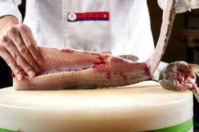 白色砧板上厨师用精湛的刀工展示鱼脍